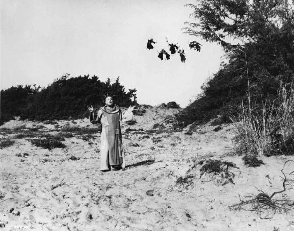 Scena del film "C'era una volta" - Regia Francesco Rosi - 1967 - L'attore Leslie French sulla spiaggia e gli attori non identificati in cielo