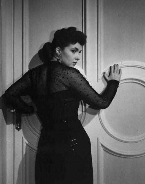 Scena del film "La città si difende" - Regia Pietro Germi - 1951 - L'attrice Gina Lollobrigida in piedi davanti a una porta