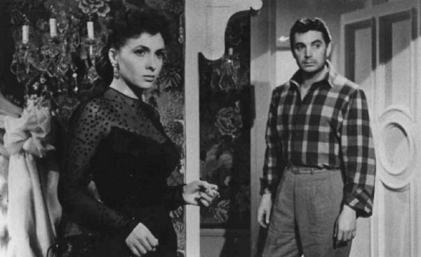 Scena del film "La città si difende" - Regia Pietro Germi - 1951 - Gli attori Gina Lollobrigida e Renato Baldini in piedi in una stanza