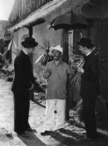 Scena del film "Come scopersi l'America" - Regia Carlo Borghesio - 1949 - Un attore non identificato e gli attori Erminio Macario e Nunzio Filogamo parlano tra loro davanti ad una casa