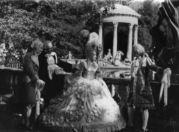 Scena del film "Il Conte di Brechard" - Regia Mario Bonnard - 1938 - Due attori non identificati osservano l'attrice Tina Lattanzi e l'attore Carlo Tamberlani mentre conversano