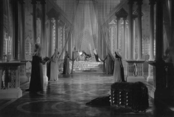 Set del film "La corona di ferro" - Regia Alessandro Blasetti - 1940 - L'attrice Elisa Cegani sullo sfondo in un interno sfarzoso.