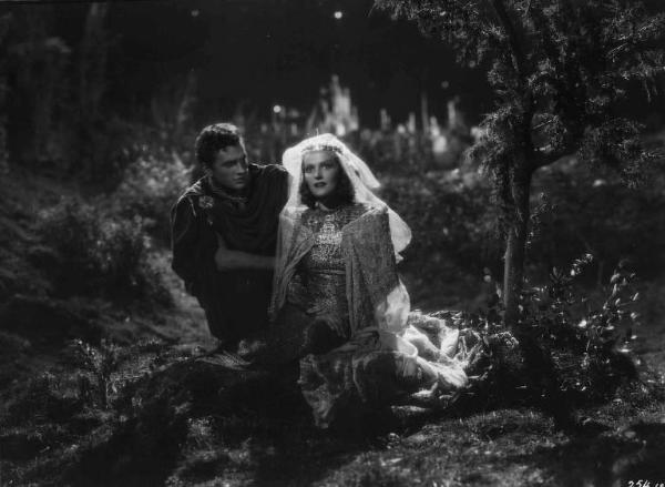 Set del film "La corona di ferro" - Regia Alessandro Blasetti - 1940 - L'attore Massimo Girotti vicino all'attrice Elisa Cegani inginocchiati in un esterno notturno.