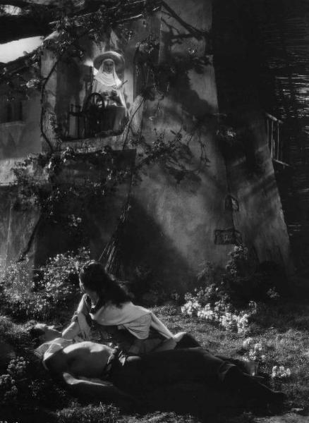 Set del film "La corona di ferro" - Regia Alessandro Blasetti - 1940 - L'attore Massimo Girotti, sdraiato a terra e l'attrice Luisa Ferida guardano verso il balcone dove sta l'attrice Rina Morelli .