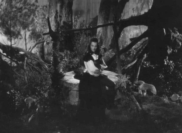 Set del film "La corona di ferro" - Regia Alessandro Blasetti - 1940 - L'attrice Luisa Ferida appoggiata ad un pozzo in un bosco fiabesco