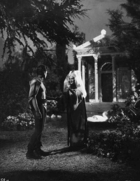 Set del film "La corona di ferro" - Regia Alessandro Blasetti - 1940 - L'attore Massimo Girotti stringe la mano all'attrice Elisa Cegani in un giardino