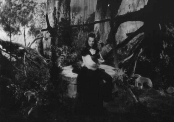 Set del film "La corona di ferro" - Regia Alessandro Blasetti - 1940 - L'attrice Luisa Ferida appoggiata al pozzo in un bosco fiabesco