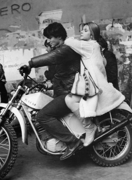 Set del film "Così come sei" - Regia Alberto Lattuada - 1978- Un attore non identificato guida una moto su cui trasporta l'attrice Nastassja Kinski.