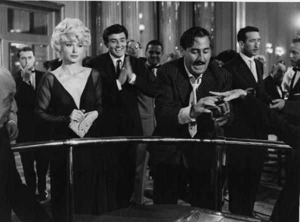 Set del film "Crimen" - Regia Mario Camerini- 1960 - L'attrice Dorian Gray, l'attore Alberto Sordi e dietro di loro l'attore Vittorio Gassman ad un tavolo di un casinò.

.