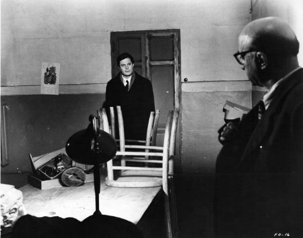 Set del film "Cronaca familiare" - Regia Valerio Zurlini 1962 - L'attore Marcello Mastroianni sul fondo di un interno con un attore non identificato in primo piano.