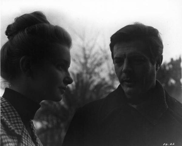 Set del film "Cronaca familiare" - Regia Valerio Zurlini 1962 - L'attrice Valeria Ciangottini e l'attore Marcello Mastroianni in primo piano all'aperto.