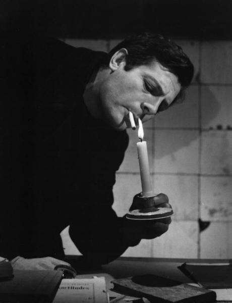 Set del film "Cronaca familiare" - Regia Valerio Zurlini 1962 - L'attore Marcello Mastroianni si accende una sigaretta con una candela.