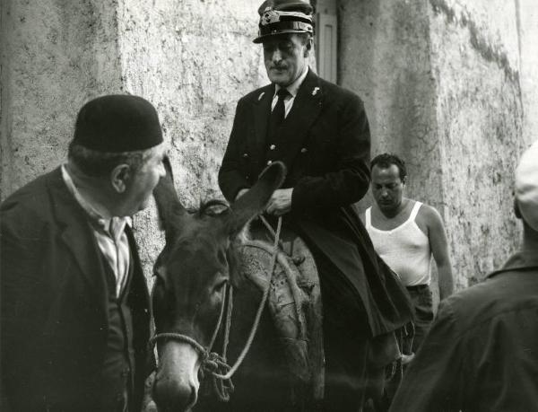 Scena del film "Destinazione Piovarolo" - Regia Domenico Paolella, 1955 - Totò a dorso di un asino è attorniato da tre uomini.