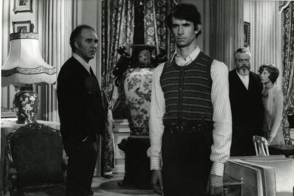 Scena del film "Dieci incredibili giorni" - Regia Claude Chabrol, 1972 - A sinistra Michel Piccoli, di profilo, guarda Anthony Perkins, al centro. Sullo sfondo, Orson Welles osserva la scena, mentre Marlène Jobert, al suo fianco, lo guarda.