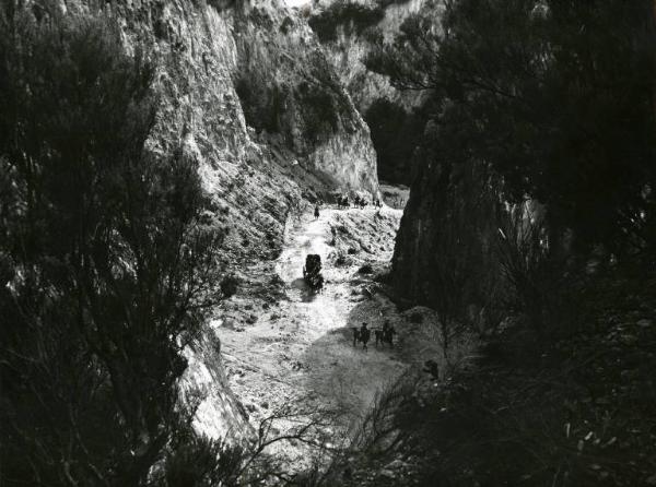 Scena del film "10.000 dollari per un massacro" - Regia Romolo Girolami, 1967 - Campo lungo di una carovana in marcia in una gola di montagna, seguita da degli uomini a cavallo.