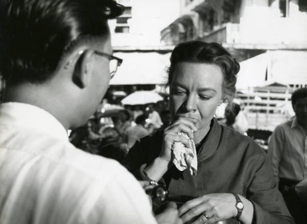 Scena del film "La diga sul Pacifico" - Regia René Clément, 1957 - Jo Van Fleet stringe un fazzoletto davanti alla bocca e guarda verso il basso. Davanti a lei, ripreso di spalle, un uomo con gli occhiali.