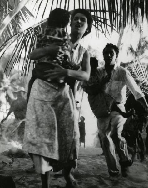 Scena del film "La diga sul Pacifico" - Regia René Clément, 1957 - Silvana Mangano e Richard Conte, entrambi con un bambino in braccio, corrono in direzione della macchina da presa.