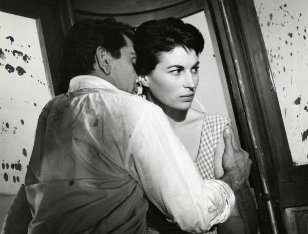 Scena del film "La diga sul Pacifico" - Regia René Clément, 1957 - All'interno di un bus sporco di fango, mezza figura di Richard Conte mentre afferra Silvana Mangano per la spalla sinistra.