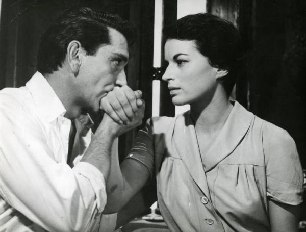 Scena del film "La diga sul Pacifico" - Regia René Clément, 1957 - Mezza figura, di profilo, di Richard Conte mentre bacia la mano di Silvana Mangano. I due si guardano.