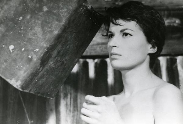 Scena del film "La diga sul Pacifico" - Regia René Clément, 1957 - Primo piano di tre quarti di Silvana Mangano, con le spalle nude. In alto a sinistra, un secchio doccia rovesciato.