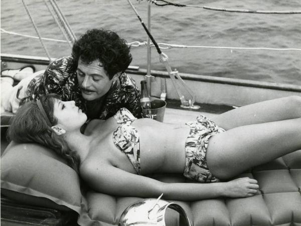 Scena del film "Divorzio all'italiana" - Regia Pietro Germi, 1961 - Su una barca, Stefania Sandrelli, prende il sole. Marcello Mastroianni, sdraiato in direzione opposta, le parla a pochi centimetri dalla bocca.