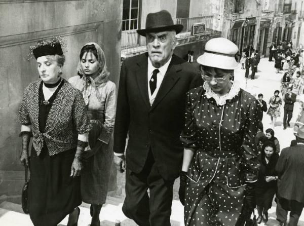 Scena del film "Divorzio all'italiana" - Regia Pietro Germi, 1961 - Bianca Castagnetta, Odoardo Spadaro e Angela Cardile salgono le scale. Margherita Girelli, dietro di loro, li segue insieme a un corteo di persone.