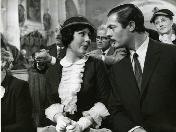 Scena del film "Divorzio all'italiana" - Regia Pietro Germi, 1961 - In una chiesa, Daniela Rocca e Marcello Mastroianni sono seduti l'una accanto all'altro e si guardano. Alle loro spalle, Angela Cardile e altri in preghiera.