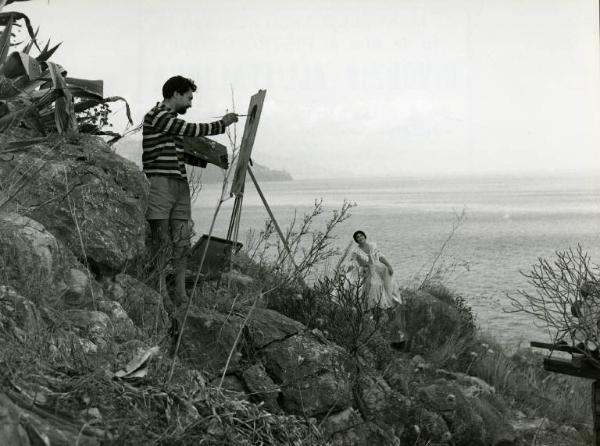 Scena del film "Divorzio all'italiana" - Regia Pietro Germi, 1961 - Su una scogliera, Leopoldo Trieste con pennello, tela e cavaletto ritrae Daniela Rocca mentre posa per lui davanti al mare.