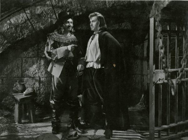 Scena del film "Don Cesare di Bazan" - Regia Riccardo Freda, 1942 - In una cella carceraria, figura intera di Enrico Glori e Gino Cervi, il primo sorride al secondo che guarda fisso di fronte a sé.