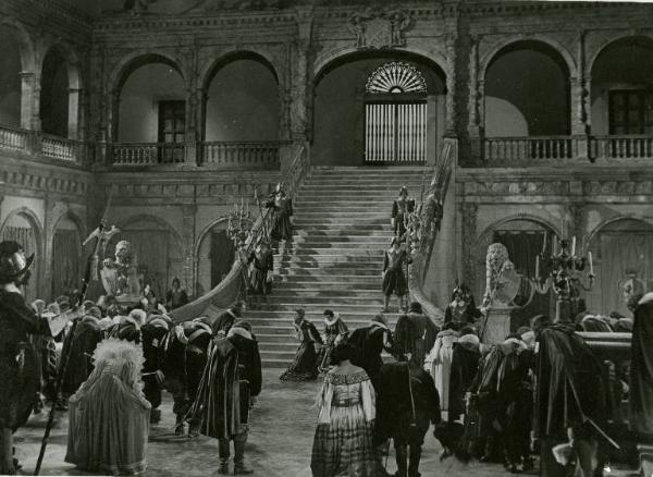 Scena del film "Don Cesare di Bazan" - Regia Riccardo Freda, 1942 - Totale. Sullo sfondo, ai piedi di una scalinata, Re e Regina si inchinano a Gino Cervi. In primo piano, uomini e donne inchinati verso i sovrani.