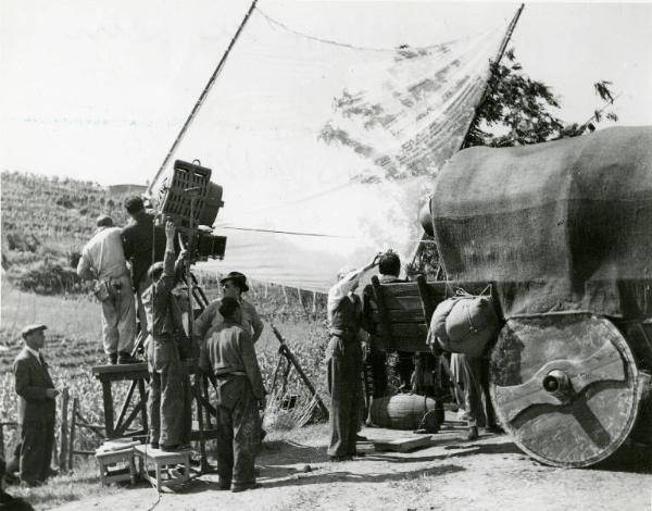 Sul set del film "Don Giovanni" - Regia Dino Falconi, 1942 - Totale. La troupe sistema un grosso telo trasparente tenendolo per i bastoni laterali al quale è legato.