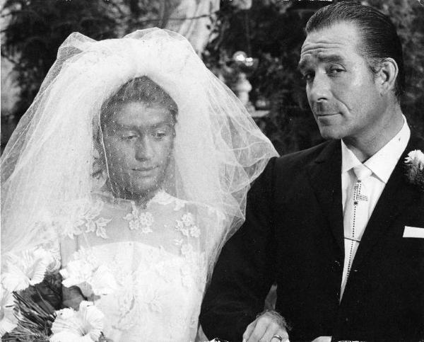 Scena del film "La donna scimmia" - Regia Marco Ferreri, 1964 - Mezza figura di Annie Girardot e Ugo Tognazzi a braccetto in abiti nuziali.