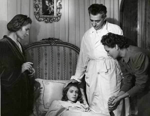 Scena del film "Domani è un altro giorno" - Regia Léonide Moguy, 1951 - Da sinistra, Bianca Doria, Anna Maria Pierangeli stesa a letto, Aldo Silvani con una mano sul suo capo e Laura Gore che le prende la mano nella sue.