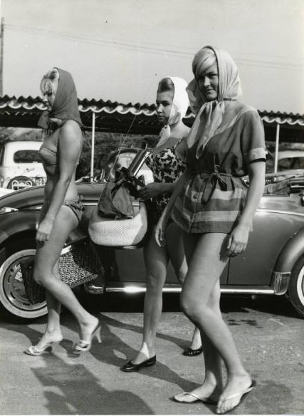 Scena del film "Una domenica d'estate" - Regia Giulio Petroni, 1962 - Figura intera di tre ragazze in costume da bagno e foulard in uno stabilimento balneare.