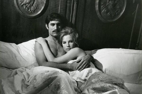 Scena del film "Don Giovanni in Sicilia" - Regia Alberto Lattuada, 1967 - In una camera da letto Lando Buzzanca, seduto e appoggiato alla spalliera del letto, abbraccia Katia Moguy che con il viso si stringe al petto nudo di lui.