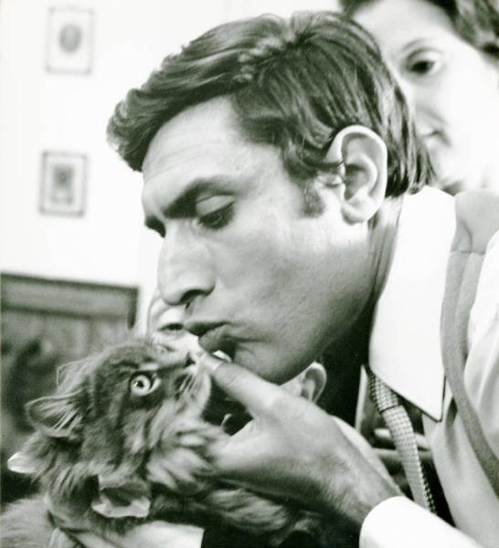 Scena del film "Don Giovanni in Sicilia" - Regia Alberto Lattuada, 1967 - Primo piano di profilo di Lando Buzzanca. L'attore solleva il muso di un gatto e distante pochi millimetri dal naso, lo bacia. Sullo sfondo una donna e un'altra persona.