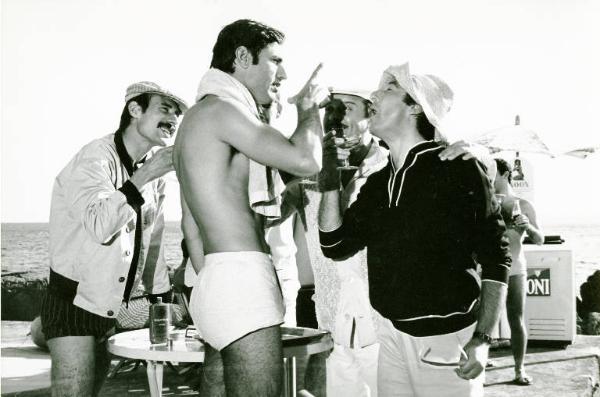 Scena del film "Don Giovanni in Sicilia" - Regia Alberto Lattuada, 1967 - Piano americano di profilo di Lando Buzzanza, in costume che alza l'indice verso un ragazzo con un calice pieno in mano. Tre uomini, dietro a loro, assistono alla discussione.