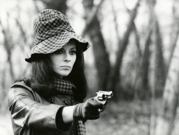 Scena del film "La donna invisibile" - Regia Paolo Spinola, 1969 - In un bosco, mezza figura di Giovanna Ralli mentre punta una pistola davanti a sé.