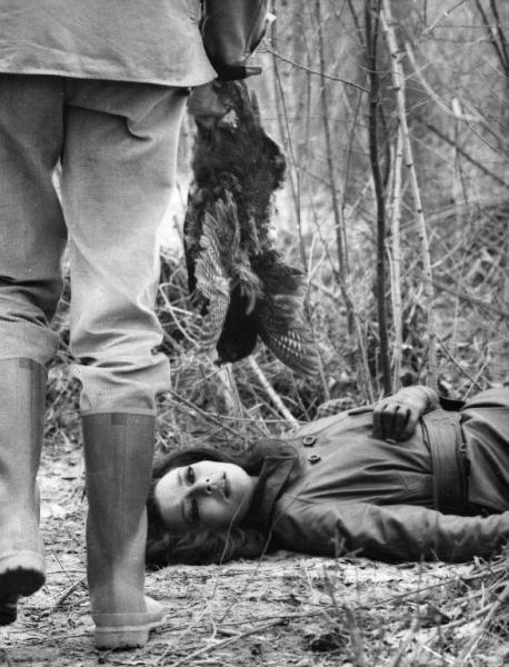 Scena del film "La donna invisibile" - Regia Paolo Spinola, 1969 - In un bosco, mezza figura di Giovanna Ralli, supina, con una mano sullo sterno. Davanti a lei ripreso di spalle dalla vita in giù, Silvano Tranquilli con in mano un uccello cacciato.