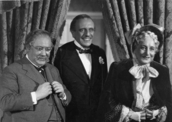 Scena del film "La donna perduta" - Regia Domenico Gambino, 1940 - Mezza figura, frontale, di Oreste Bilancia, Alberto Capozzi e Mary Cleo Tarlarini. I tre attori, sorridono.