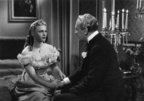 Scena del film "La donna perduta" - Regia Domenico Gambino, 1940 - Mezza figura di Luisella Beghi e Alberto Capozzi. I due attori sono seduti uno di fronte all'altra, si tengono per mano, e si fissano intensamente.