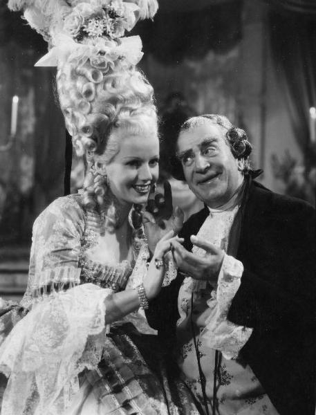 Scena del film "Don Pasquale" - Regia Camillo Mastrocinque, 1940 - Mezza figura di Laura Solari. Al suo fianco, Armando Falconi che, con una mano alza l'indice al cielo e con l'altra mano, sfiora quella di lei.