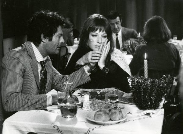 Scena del film "Dramma della gelosia (tutti i particolari in cronaca)" - Regia Ettore Scola, 1970 - Monica Vitti tiene le mani di Marcello Mastroianni mentre le accarezza il viso. I due siedono al tavolo di un ristorante.