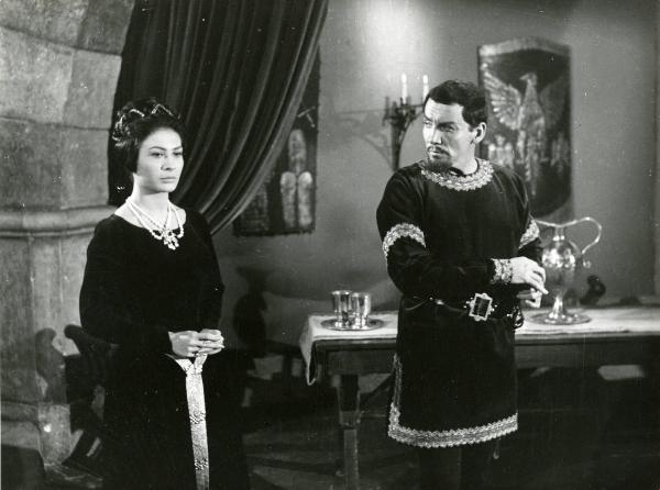 Scena del film "Il duca nero" - Regia Pino Mercanti, 1963 - Piano americano di Gloria Milland, sulla sinistra, e Cameron Mitchell, sulla destra. Sullo sfondo un tavolo con sopra due calici.