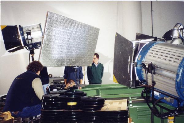 Sul set del film "Due dollari al chilo" - Regia Paolo Lipari, 2000 - Alcune bobine di pellicola 35 mm in attesa di essere processate dalla macina per pellicole. La troupe allestisce il set. Al centro della scena, Matteo Pavesi.