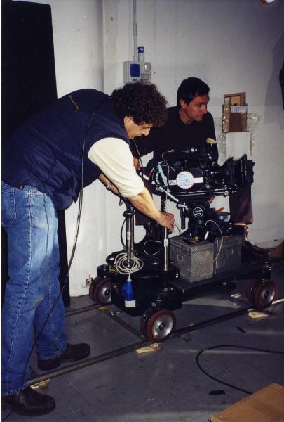 Sul set del film "Due dollari al chilo" - Regia Paolo Lipari, 2000 - Due membri non identificati della troupe manovrano la macchina da presa su un carrello.