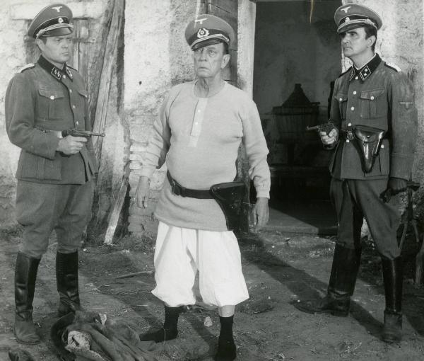 Scena del film "Due marines e un generale" - Regia Luigi Scattini, 1965 - Alessandro Sperli, a sinistra, e Alfredo Adami, a destra, attorniano Buster Keaton, in centro, puntandogli le rispettive pistole.