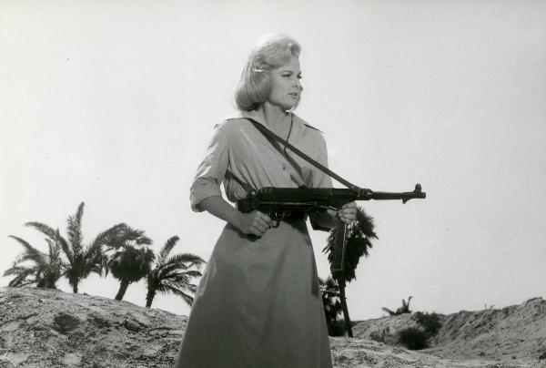 Scena del film "Due marines e un generale" - Regia Luigi Scattini, 1965 - Piano americano di Martha Hyer mentre imbraccia una pistola mitragliatrice.