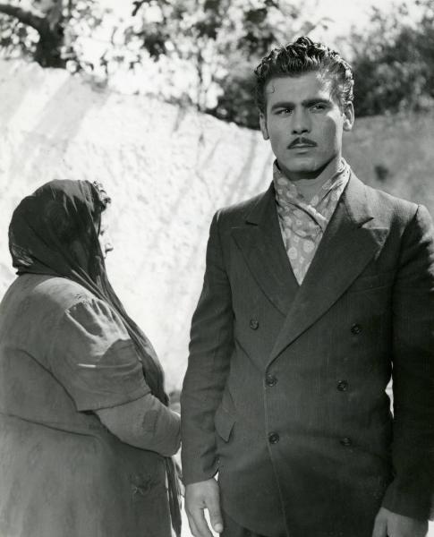 Scena del film "Due soldi di speranza" - Regia Renato Castellani, 1952 - A destra, Vincenzo Musolino guarda dritto davanti a sé, affiancato da un'attrice non identificata a capo coperto.