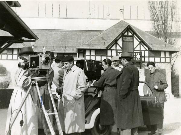 Sul set del film "È caduta una donna" - Regia Alfredo Guarini, 1941 - Sul set, operatori non identificati intorno a un'autovettura, dialogano tra loro.